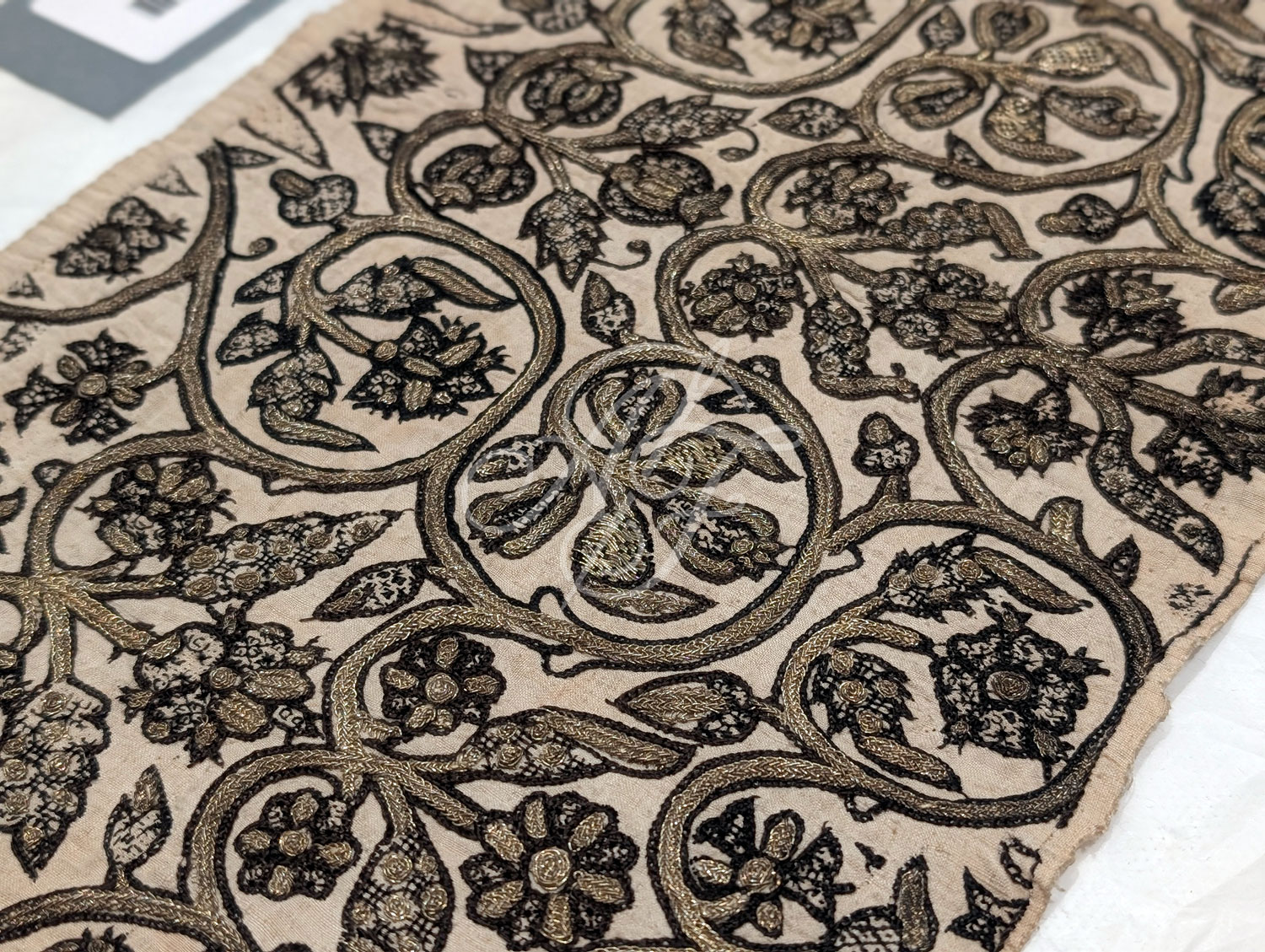Closeup blackwork embroidery and gold braid on a late Elizabethan linen coif cap