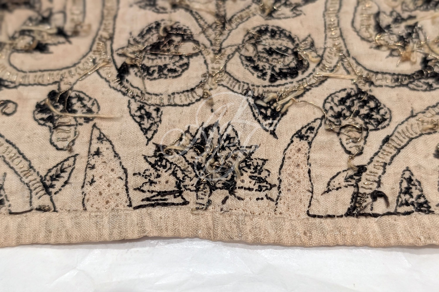 Close up of the embroidery on an extant Elizabethan linen coif with blackwork and gold braid